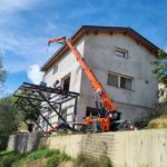 Grue araignée utilisée pour poser une charpente métallique pour une extension de maison