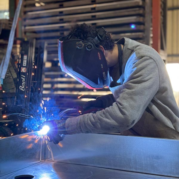 Un soudeur ferronnier travaillant sur une pièce métallique