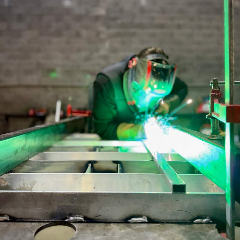 Un soudeur ferronnier qui assemble des tôles métalliques